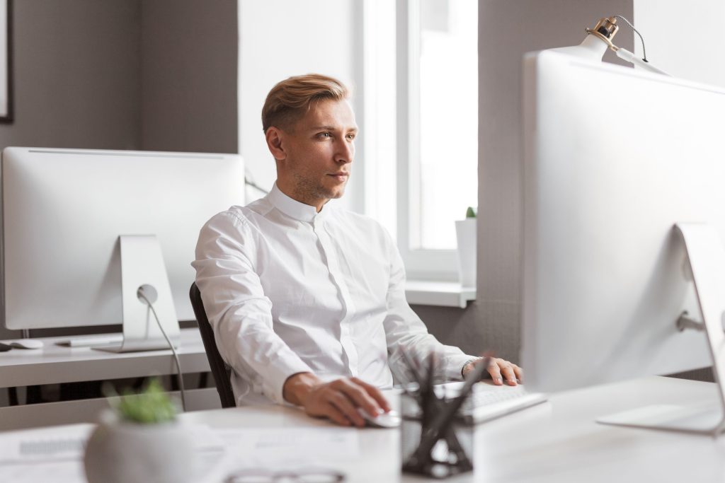Serious man using computer in office