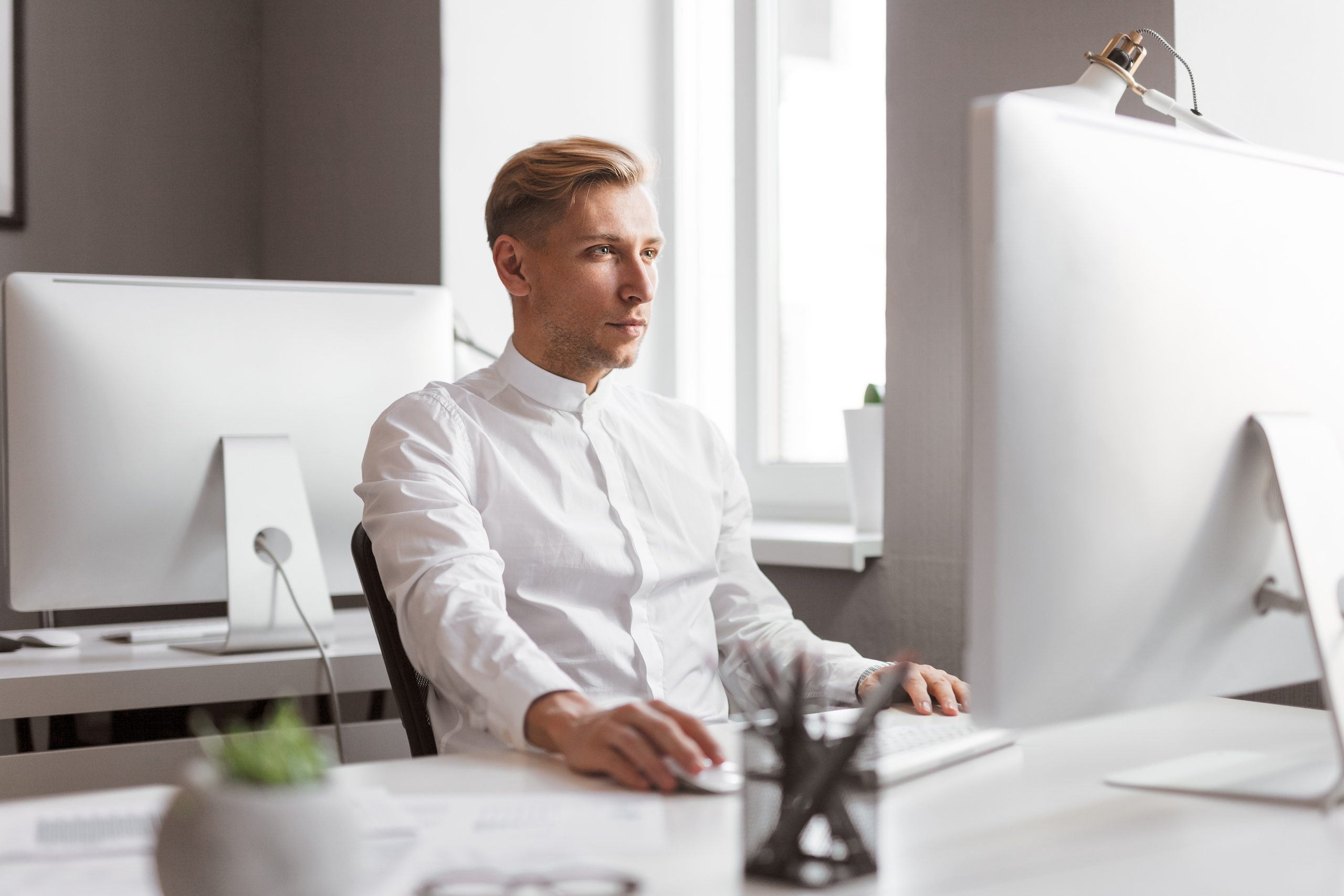 Serious man using computer in office